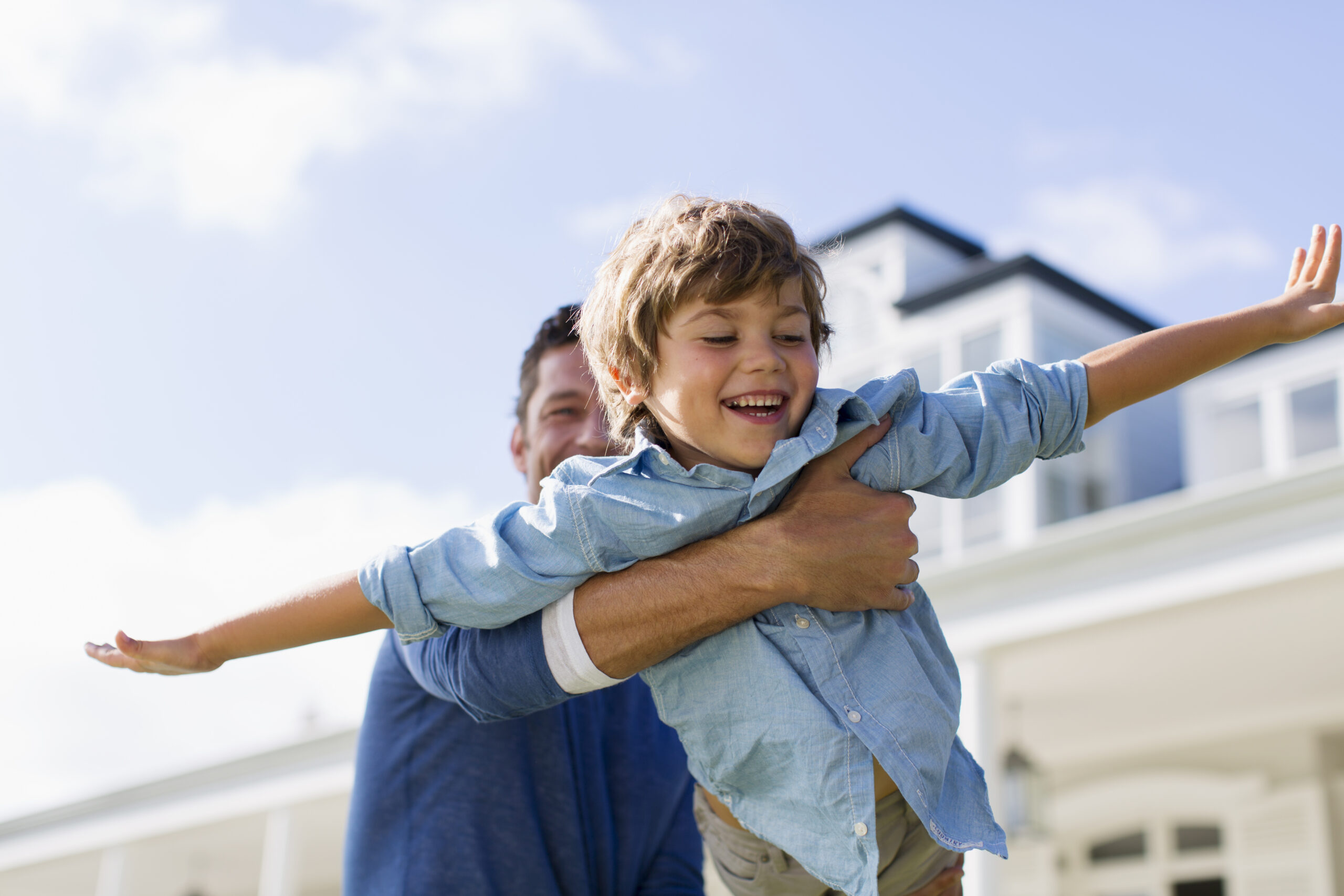 Playful father flying son